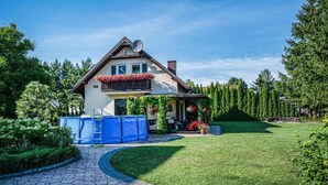 A house with a covered porch, a fenced yard, and a stone pathway leading to the entrance. - 2 bedroom amazing home in Ploskinia (Ploskinia)