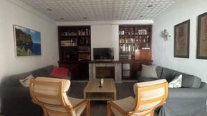 Ein Wohnzimmer mit Kamin, zwei Schaukelstühlen, einem Couchtisch und einem Fernseher.
