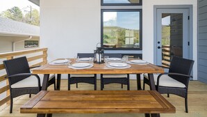 A wooden dining table set with plates, glasses, and a lantern.