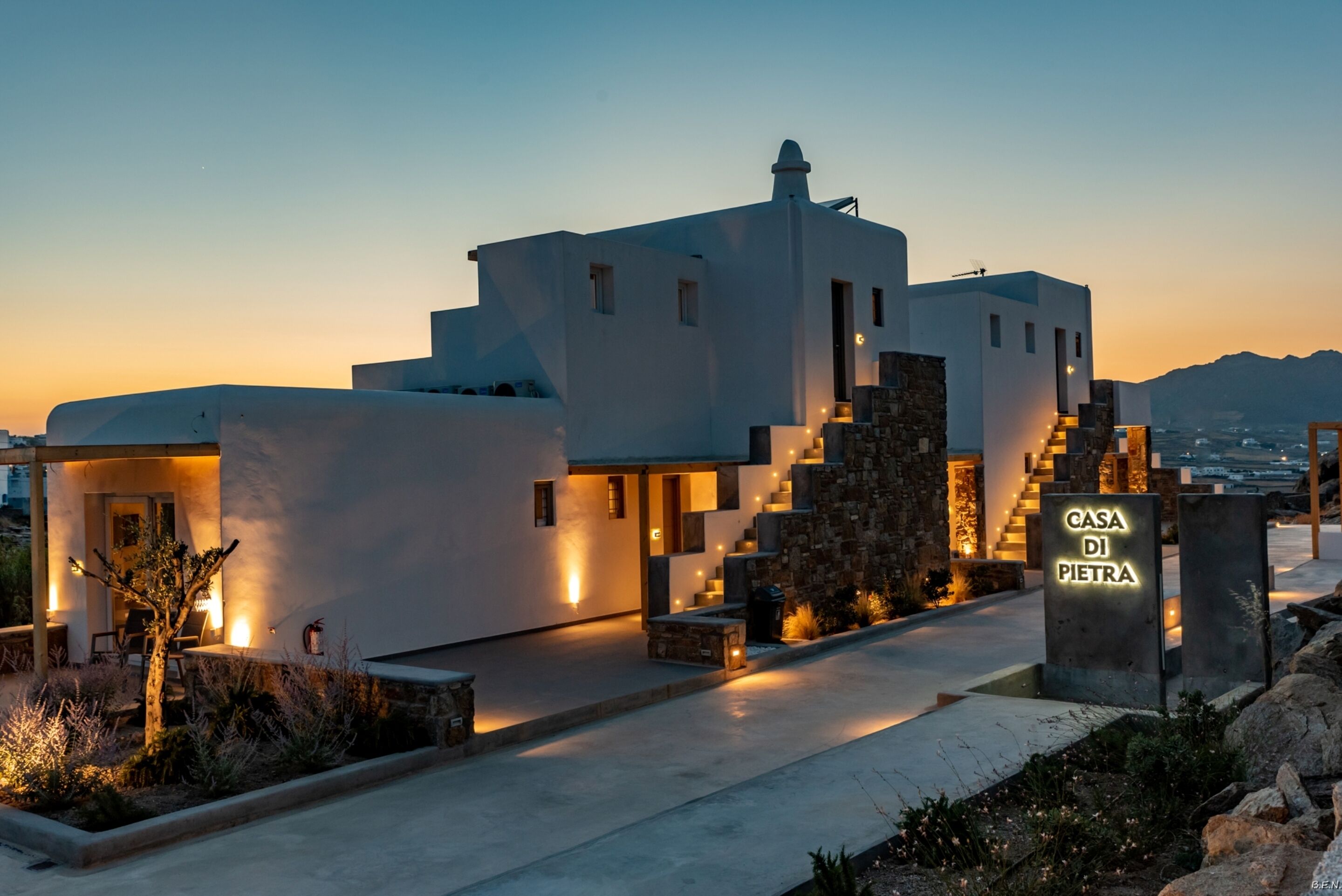 Una villa moderna con una escalera de piedra, una entrada bien iluminada y un letrero que dice "Casa Di Pietra".