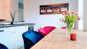 Una cocina moderna con armarios blancos, lavavajillas Siemens y encimera de madera.