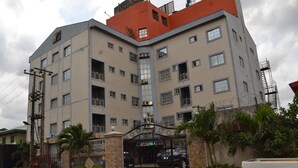 A multi-story building with a gated entrance, balconies, and a sign indicating a business or commercial use. - Valley Front View Hotel (Lagos)