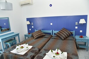 Una habitación de hotel con dos camas, un escritorio, una silla y una mesita de noche.