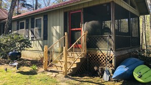 A rustic cabin with a red door, a porch, and a screened area. - Owl’s Perch-lakefront, paddle boards, pool table (Mentone)
