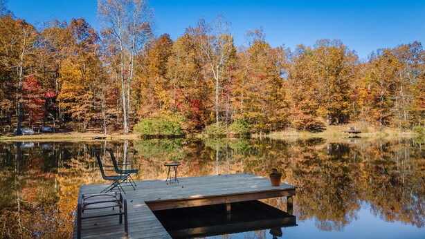 A wooden dock extending into a calm lake, surrounded by autumn-colored trees. - Owl’s Perch-lakefront, paddle boards, pool table (Mentone)