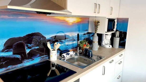 A kitchen with a large island, a microwave, and a sink.