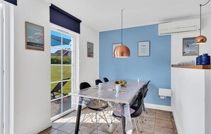 Enjoy meals in this cozy dining area with a glass table and chairs, surrounded by a beautiful view.
