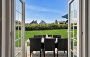 Enjoy meals and drinks in an outdoor space with a view of the well-maintained lawn.