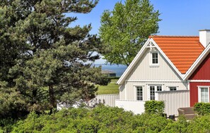 Traditional house surrounded by lush greenery and a serene natural setting.