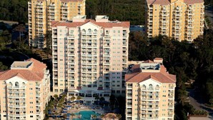 A high-rise hotel with multiple balconies, a central swimming pool, and a beachside location. - Oceanfront Villa at Grand Dunes (Myrtle Beach)