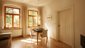 A dining area with a table and chairs, a radiator, and a door. - Stylishly furnished vacation apartment in Dresden including bicycles, close to the city center (Dresden)
