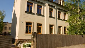 A multi-story building with a flat facade, several windows, and a wooden fence in the foreground. - Stylishly furnished vacation apartment in Dresden including bicycles, close to the city center (Dresden)