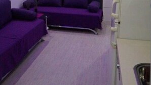 A room with purple walls, a purple sofa, and a white cabinet. - Modern Studio A4 for 2-3 people with 2 swimming pools (Pag)