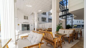 A spacious lobby with high ceilings, a reception area, and multiple seating arrangements. - Club Efes Otel (Silifke)