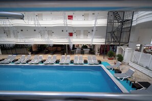 A pool area with sun loungers, a staircase, and a mezzanine level with railings. - Club Efes Otel (Silifke)
