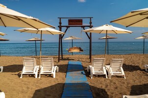 Na praia, barracas de praia de cortesia, espreguiçadeiras, guarda-sóis