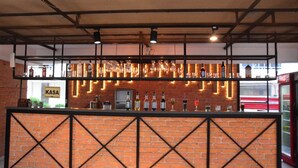 A bar area with a brick wall, a sign reading 'KASA', and a variety of bottles and glasses on display. - Club Efes Otel (Silifke)