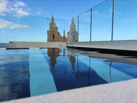 Una piscina cubierta, una piscina al aire libre, tumbonas