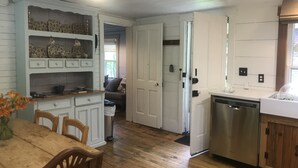 A kitchen with wooden cabinets, a dining table with chairs, and a dishwasher.