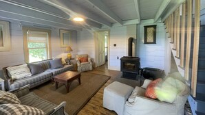 A cozy living room with a fireplace, a sofa set, and a dining table.