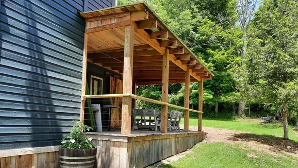 A wooden deck attached to a house with a covered patio area.