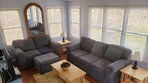 A living room with two grey sofas, a wooden coffee table, and a patterned rug.