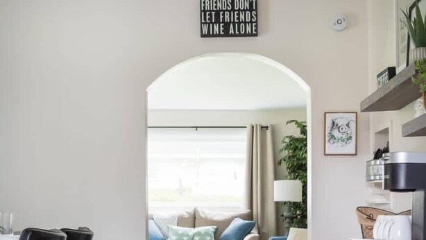 A modern kitchen with a dining area, a coffee machine, and a sign that reads "FRIENDS DON'T LET FRIENDS WINE ALONE." - Cedar Creek Cottage-Idyllic Setting & Dog Friendly (Cedar)