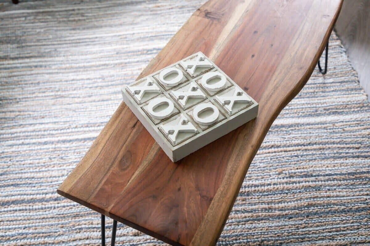 A wooden bench with a white, geometric object on it.