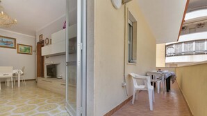 Een kamer met een eethoek, een schuifdeur en een balkon met een hekwerk.