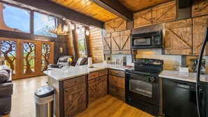 A rustic kitchen with wooden cabinets, a built-in microwave, a stove, and a dishwasher. - Stunning view, location & Cabin amenities- 2.3 mi to Gatlinburg (Gatlinburg)