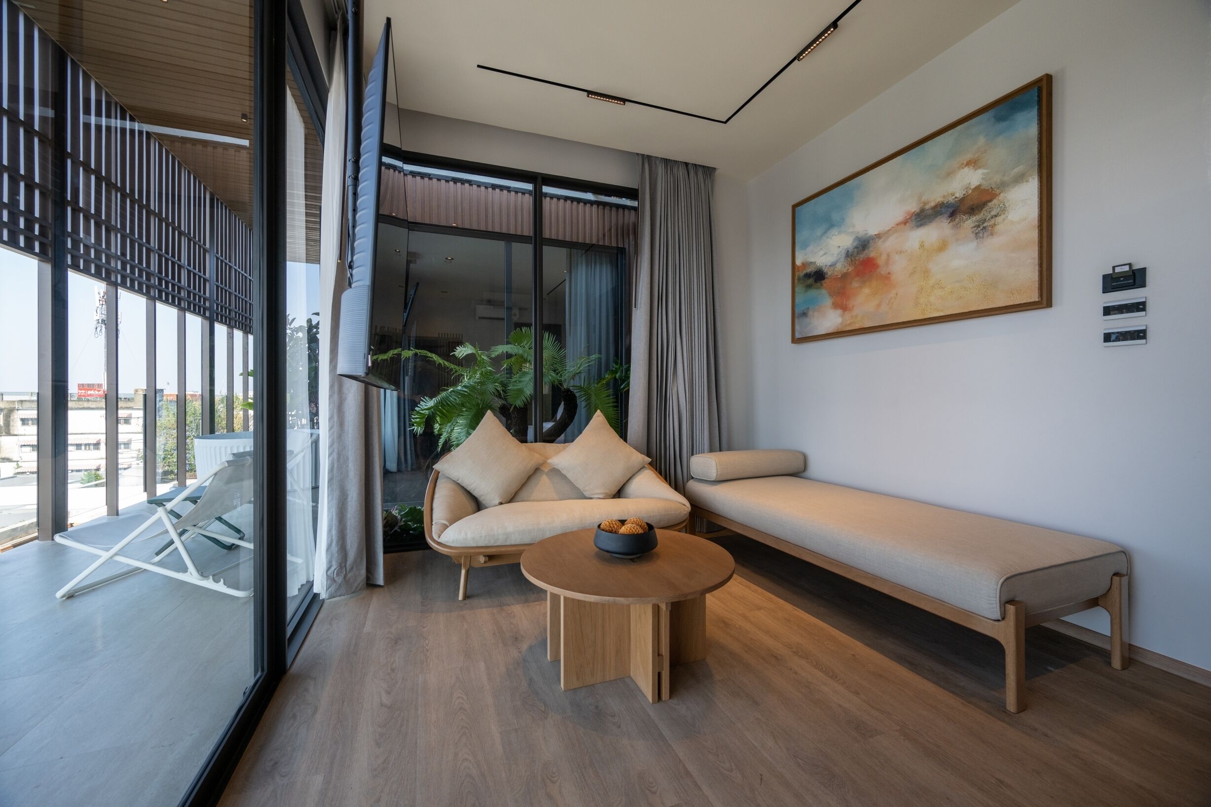 Una sala de estar moderna con un sofá, un banco y una mesa de centro redonda.