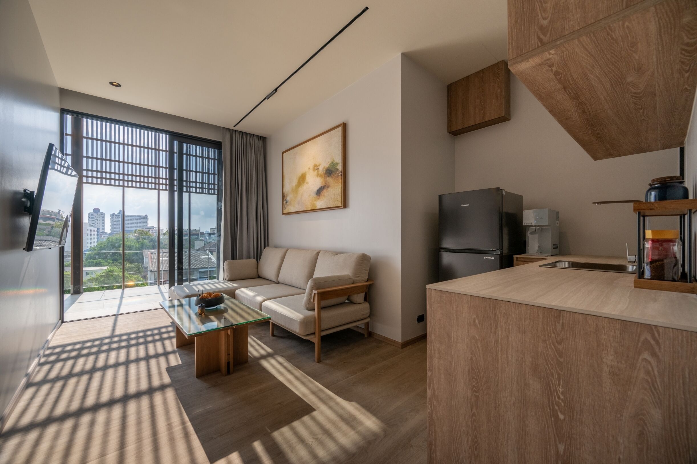 Un salon moderne avec un canapé, une table basse et une vue dégagée grâce à de grandes fenêtres.