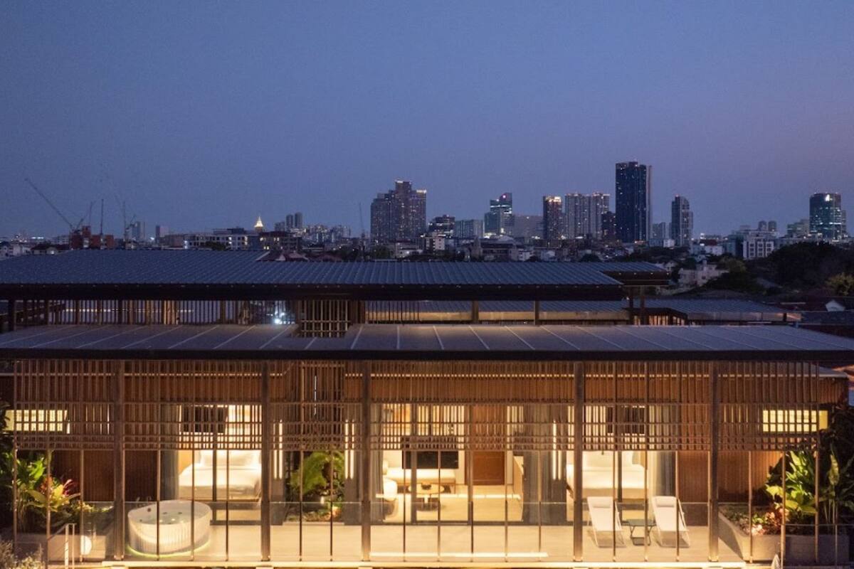 En modern byggnad med stora fönster och en stadsbild som syns i bakgrunden.