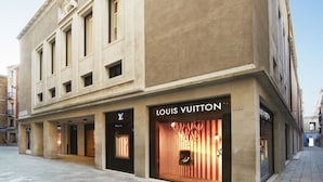 A building with a Louis Vuitton store on the ground floor, featuring a large, illuminated storefront with a striped pattern. - APARTMENT San Moisè Terrace! 90mt St.MARK\'S square (Venezia)
