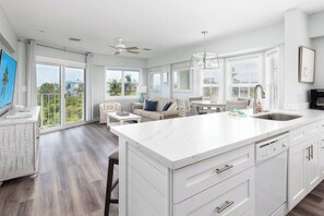 Amplia sala de estar con una isla grande en la cocina, una mesa de comedor y un sofá.