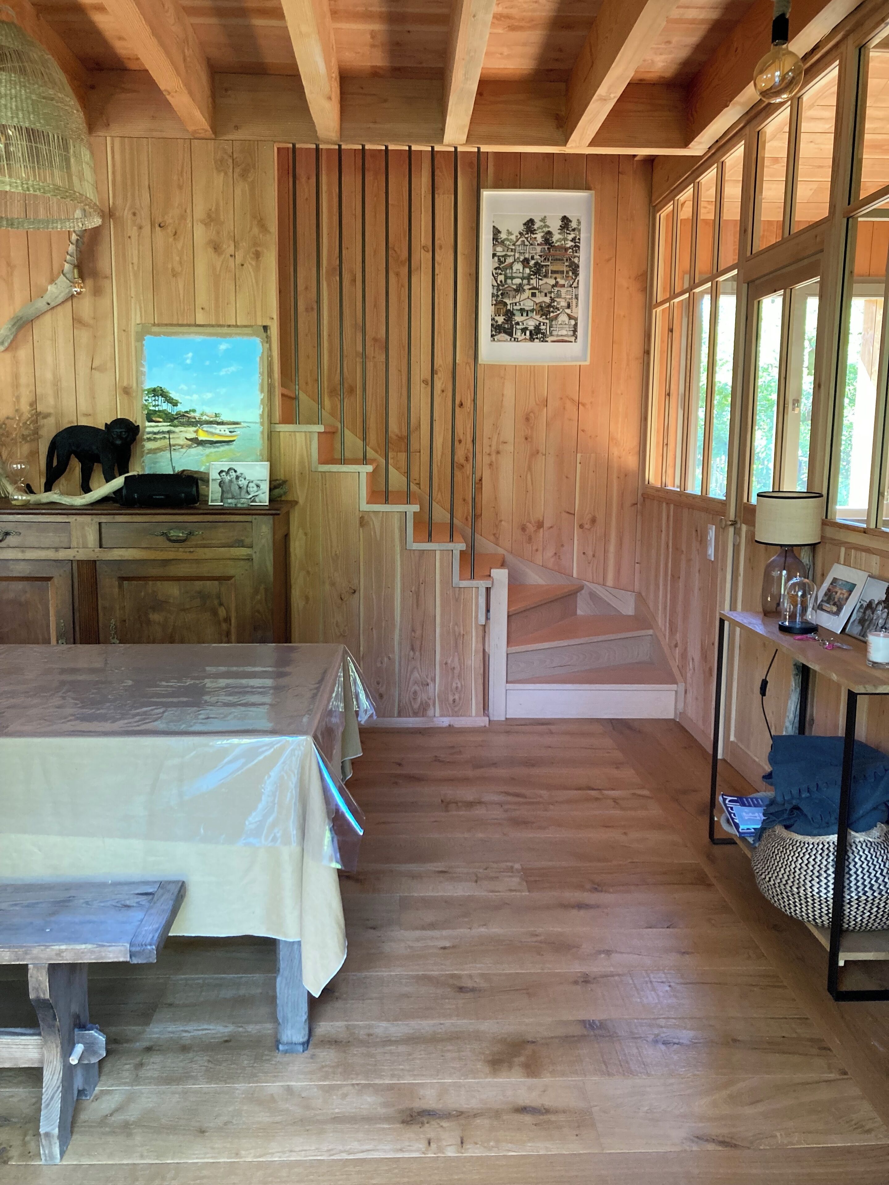 Ein Holzkamin mit Treppe, einem Schreibtisch mit einer schwarzen Katzenfigur und einem gerahmten Bild an der Wand.