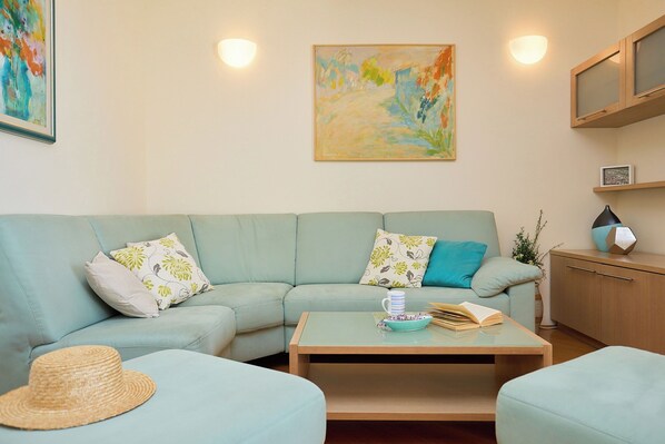 A living room with a light blue sofa, a coffee table, and a painting on the wall.