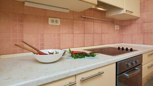A kitchen with a white countertop, a stove, and cabinets. - Apartment Terra - Three Bedroom Apartment, Sleeps 5 (Dubrovnik)