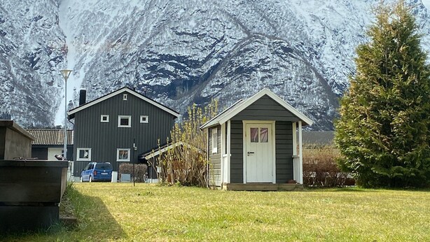 A residential area with houses, a grassy yard, and a snow-covered mountain in the background. - Newly renovated basement apartment with nice view (Møre og Romsdal)