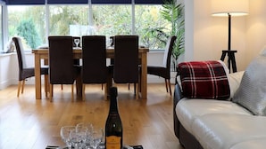 A dining area with a table set for four, a bottle of Prosecco, and glasses on a tray. - No 1 Ashey (Ryde)