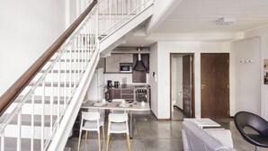 Eine moderne Wohnung mit Treppe, einer Küche, einem Essbereich und einem Wohnraum.
