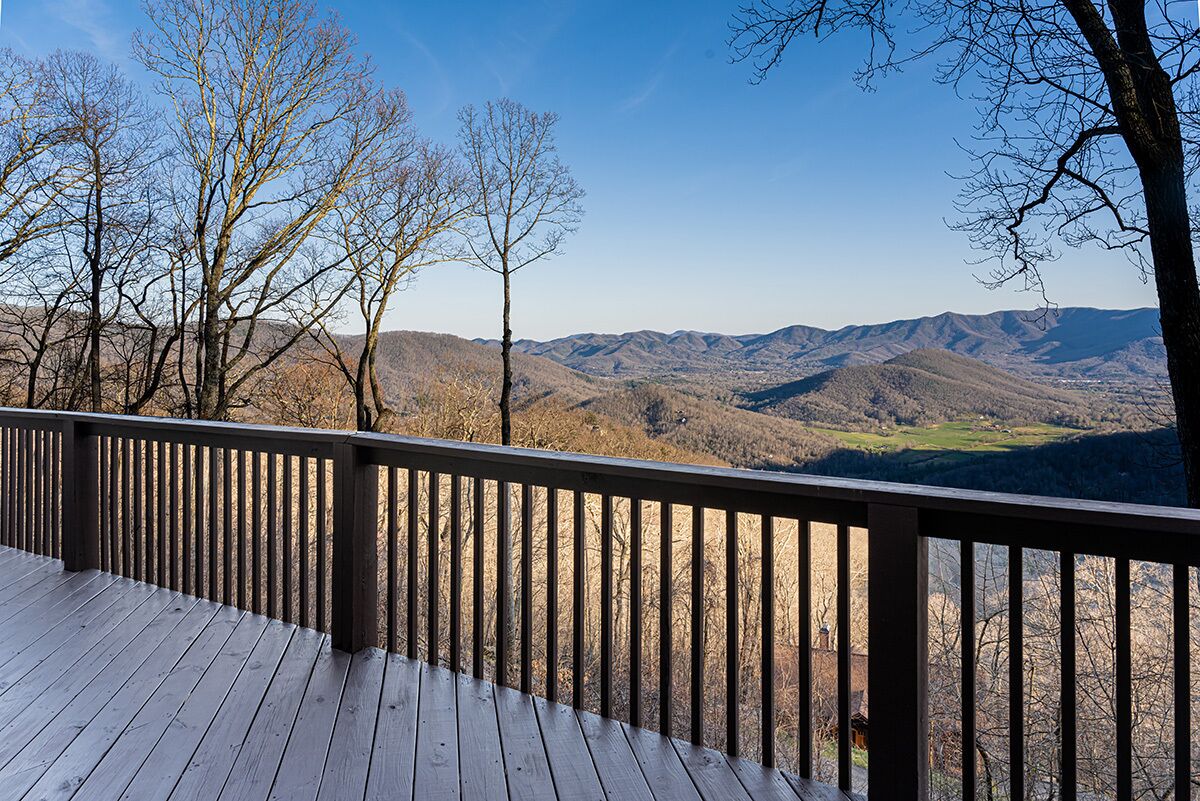 A wooden deck with a view of a mountainous landscape.