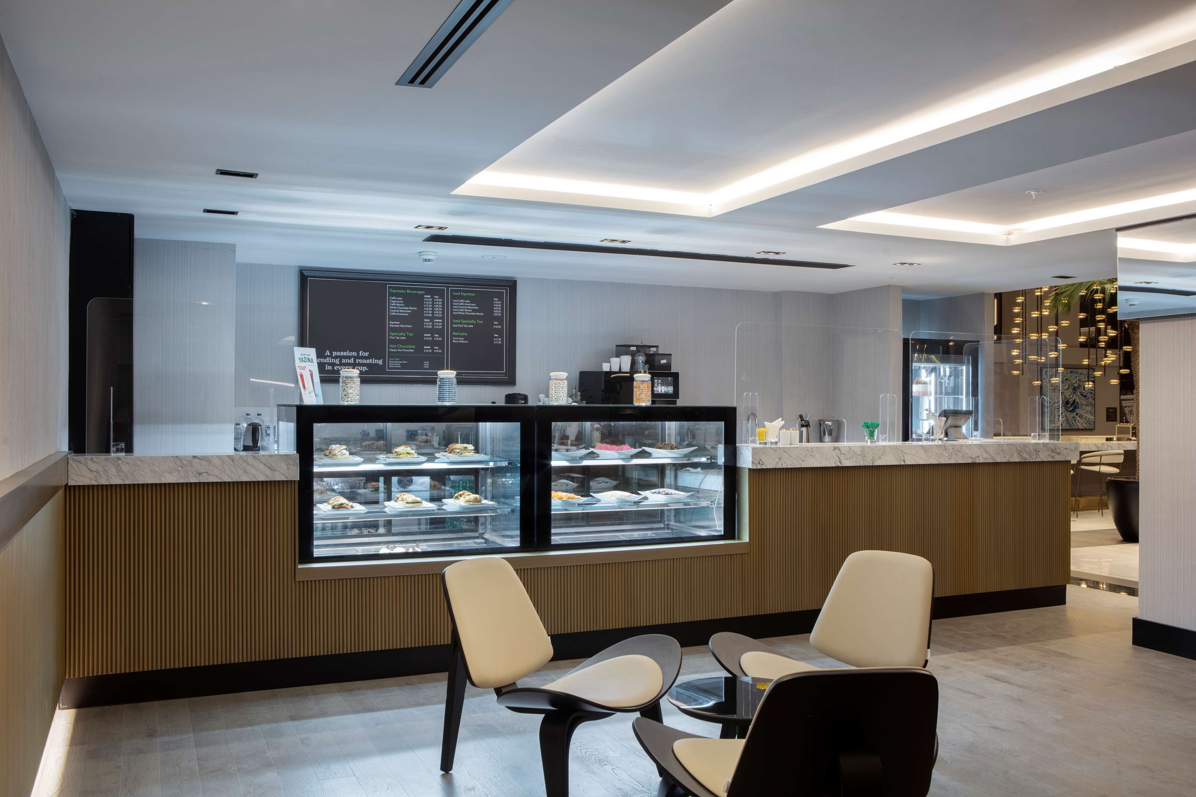 A modern restaurant with a counter, display cases, and seating area.