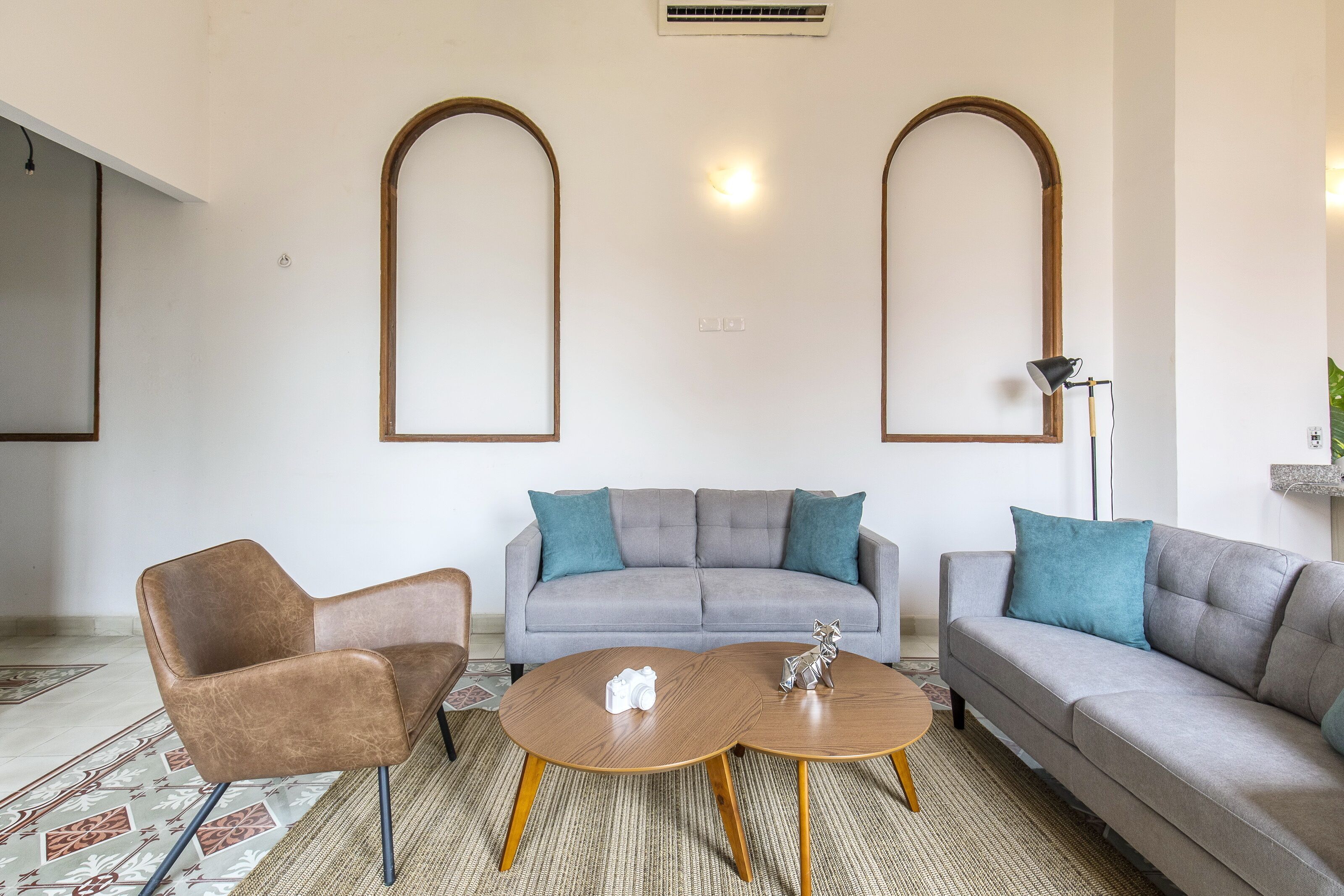 A modern living room with a grey sofa, two armchairs, and a coffee table.