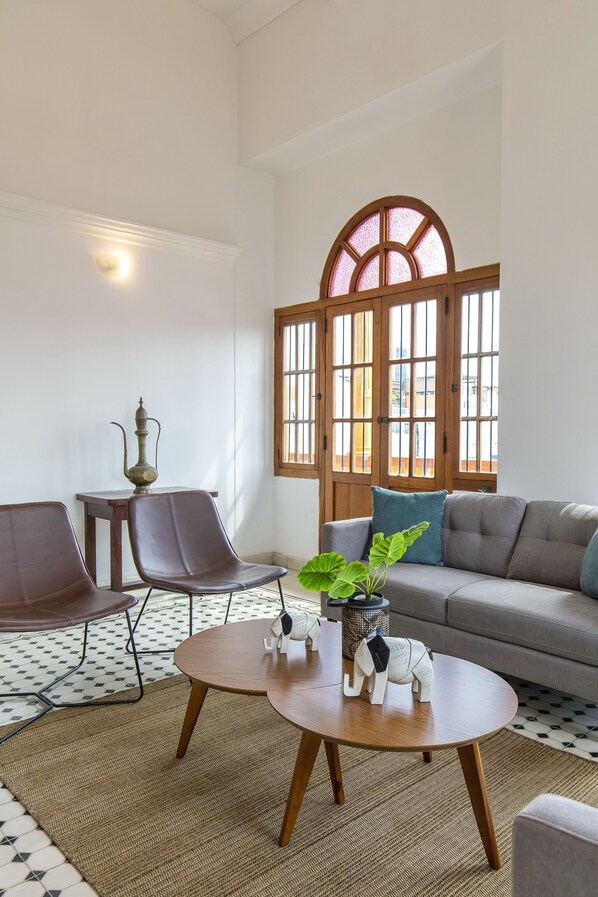 Una sala de estar moderna con un sofá, dos sillones, una mesa de centro redonda y una figurita decorativa de elefante.