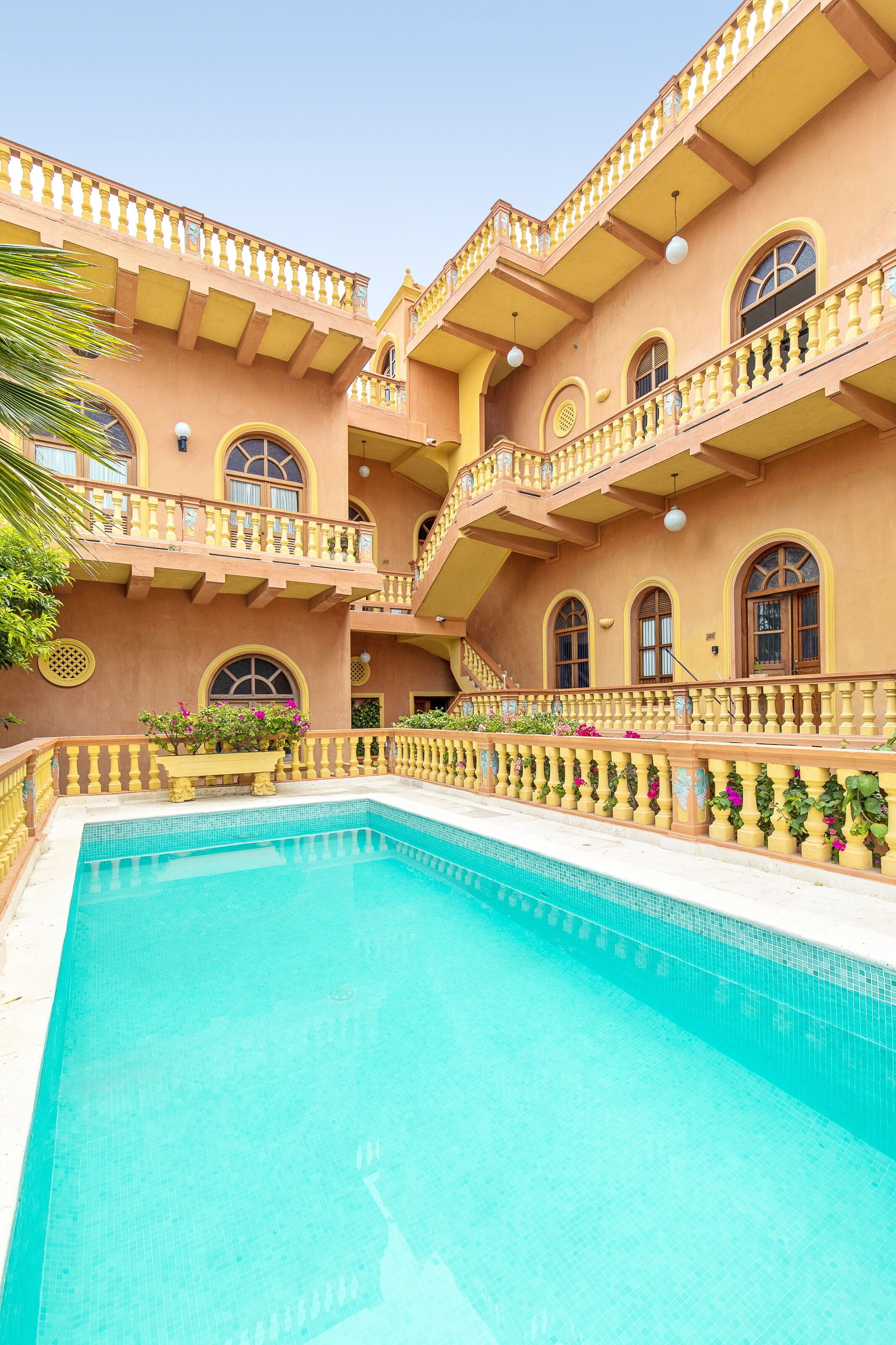 Un immeuble à plusieurs étages doté d’une piscine, de balcons et d’un escalier.