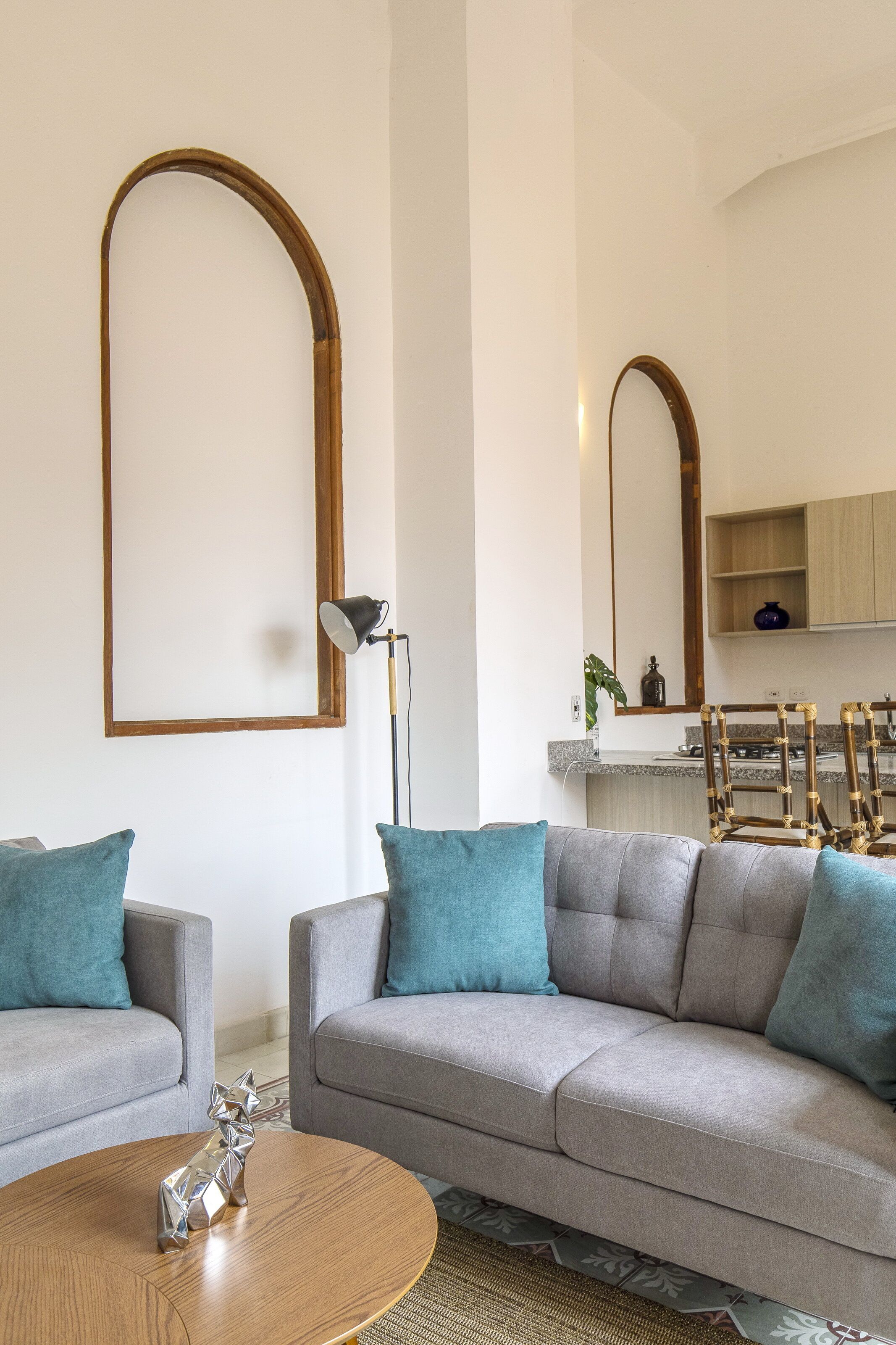 A modern living room with two sofas, a coffee table, and a lamp.