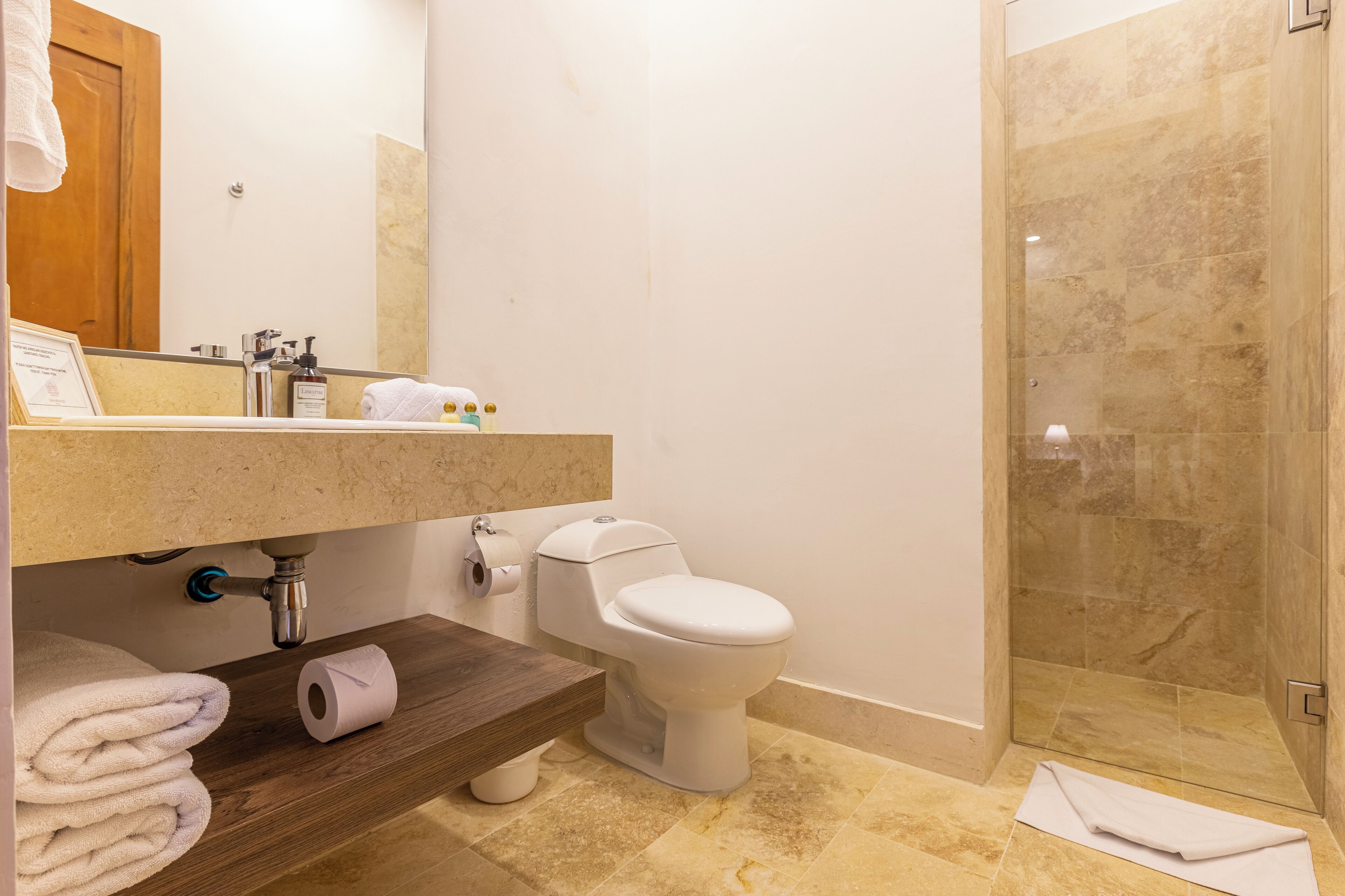 A modern bathroom with a toilet, sink, and shower area.