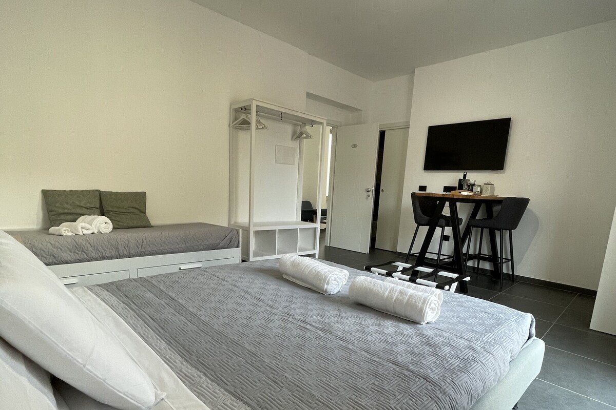 Une chambre d’hôtel moderne, dotée d’un grand lit, d’un bureau et d’une télévision.