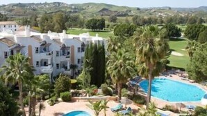 A resort with a pool, palm trees, and a view of the surrounding landscape. - Stylish one bed apartment at Matchroom CountryClub (Las Lagunas de Mijas)